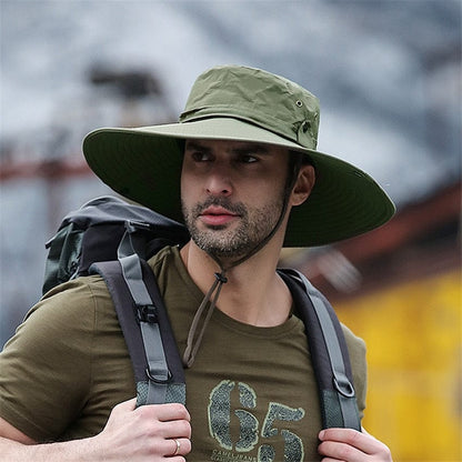 An angler wearing an army green wide-brim fishing hat with the side brims buttoned up