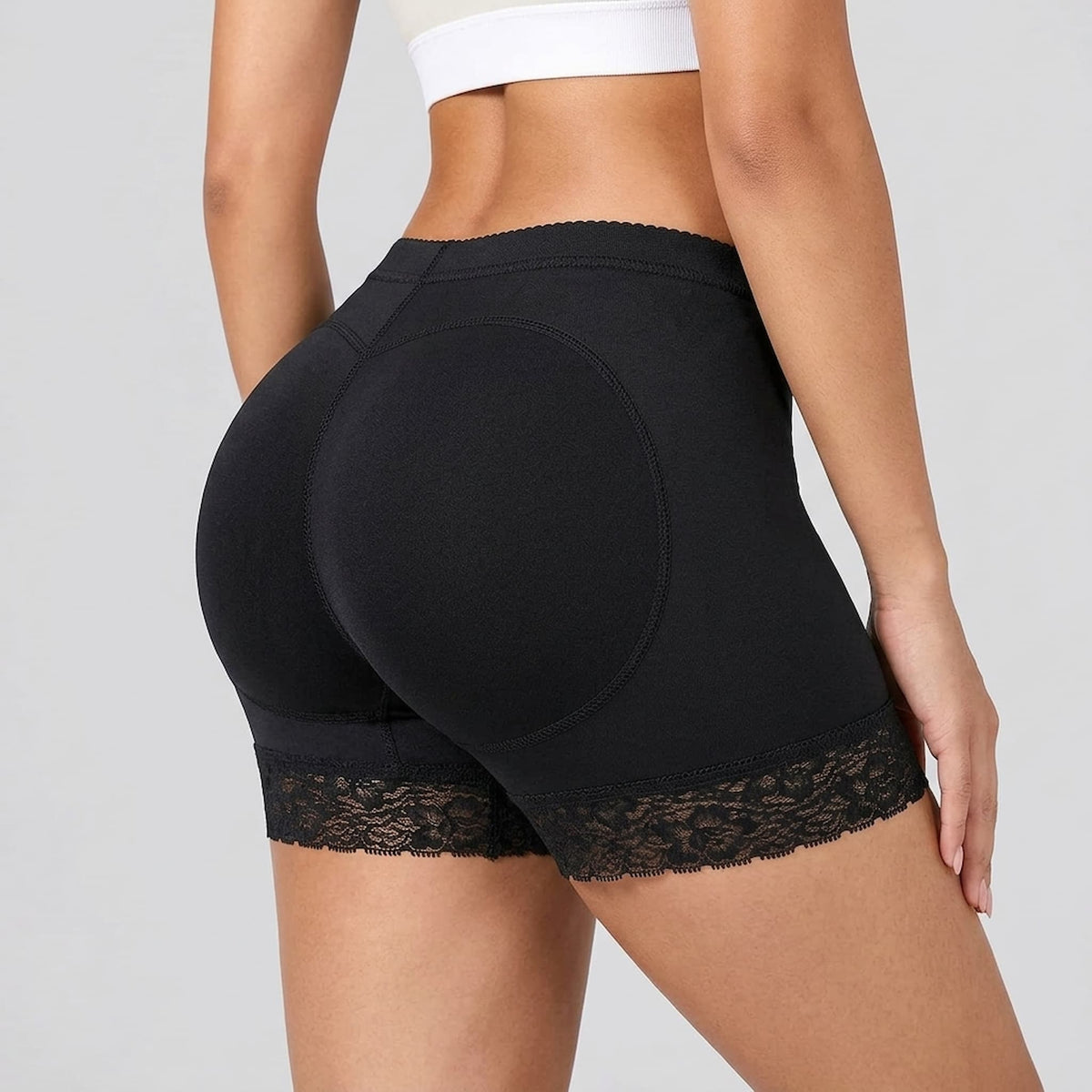 butt enhancing underwear shown on a model from a rear three-quarter angle against a light gray studio background.