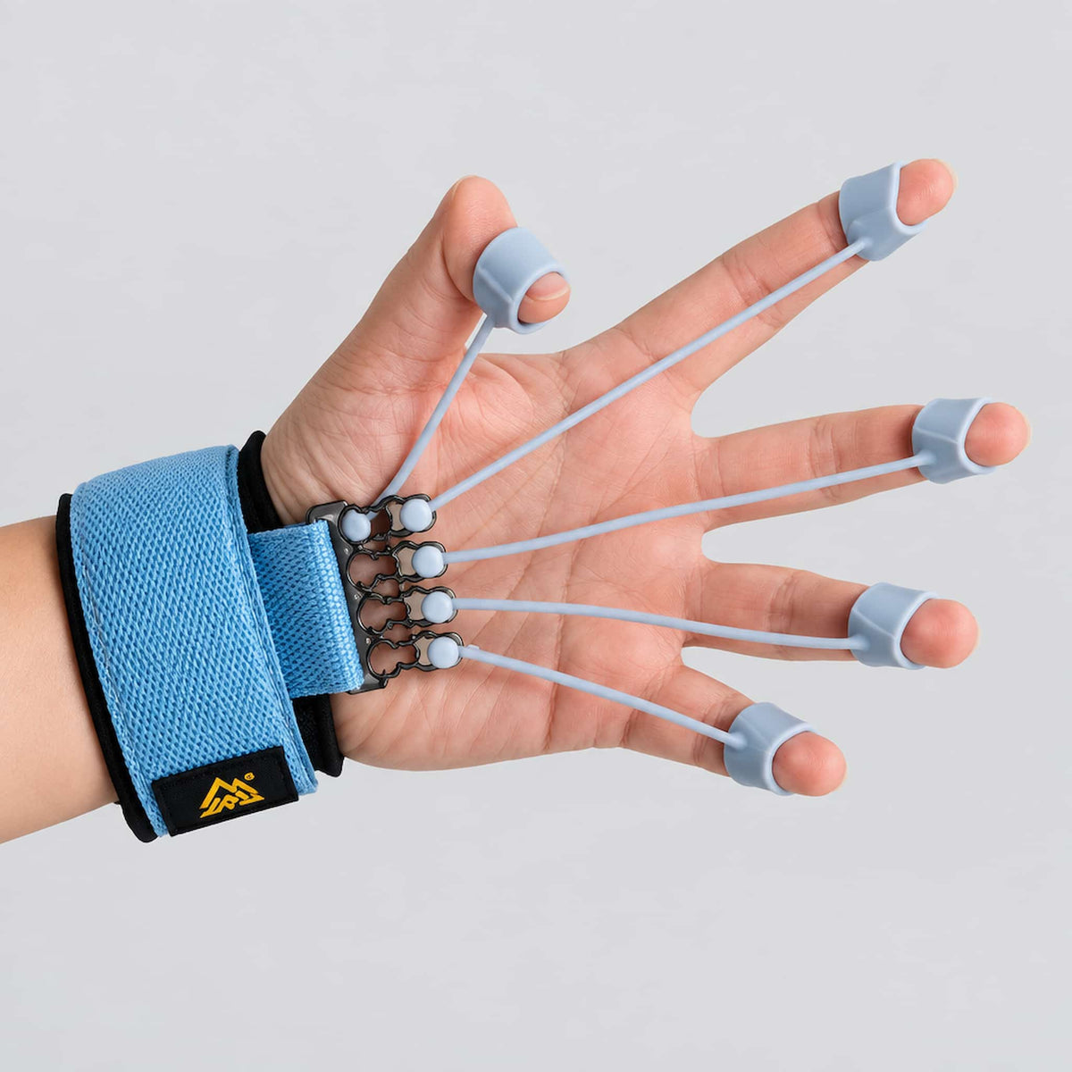 A hand wearing a finger dexterity trainer, shown against a light gray background.