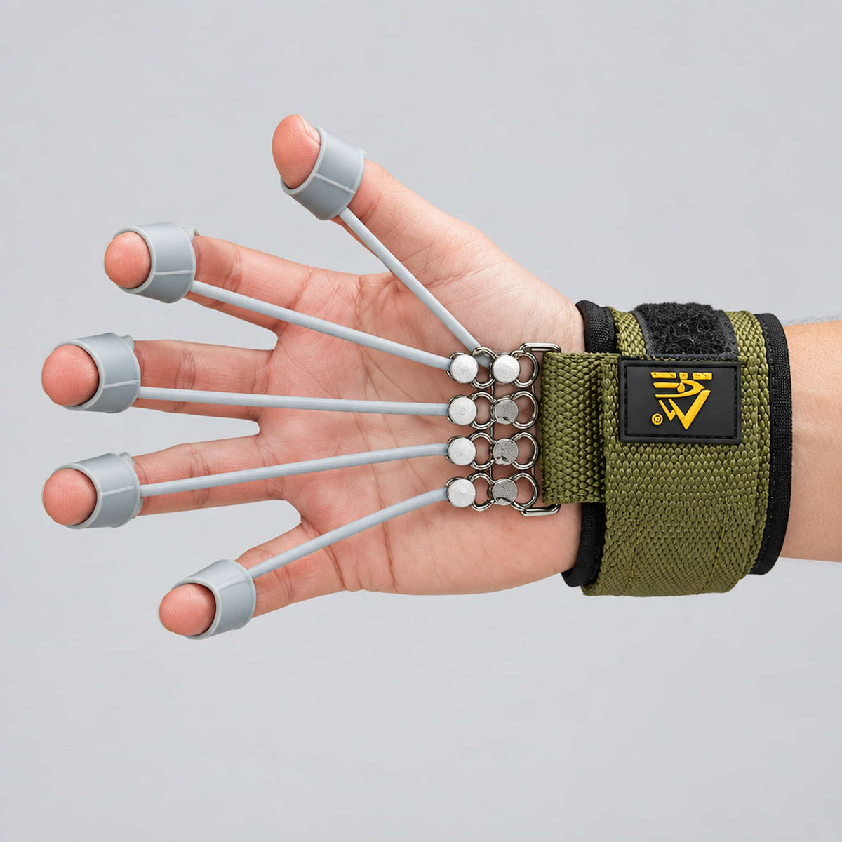 A hand wearing a finger gripper strength trainer, featuring a yellow logo patch.