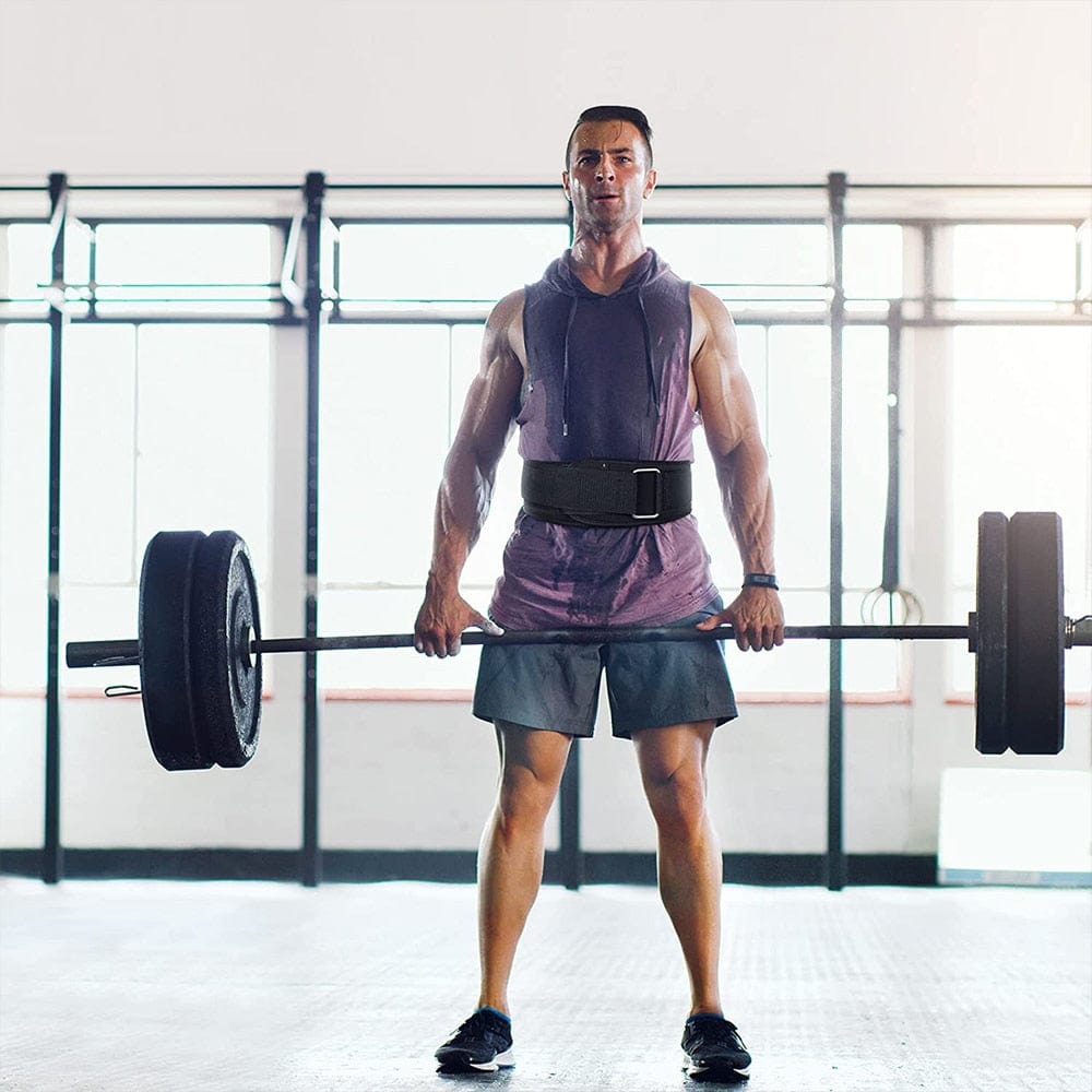An active bodybuilder executing a heavy barbell squat while maintaining proper linear spine alignment with a black gym belt.