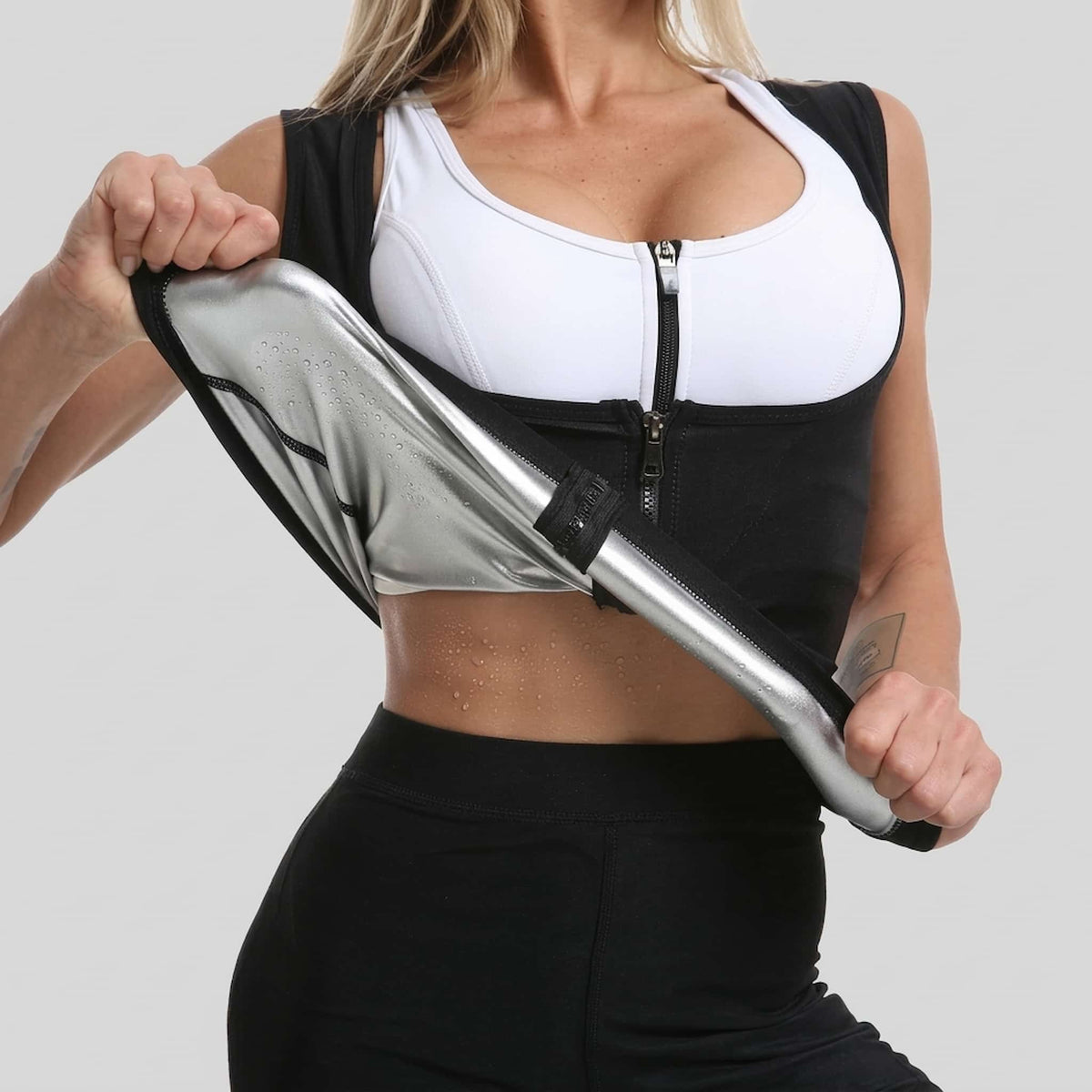 A woman wearing a heat trapping workout vest against a light gray background.