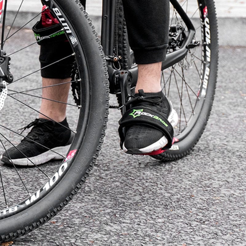 A cyclist riding a fixed-gear commuter bike through city streets with a heavy-duty foot retention system visible.