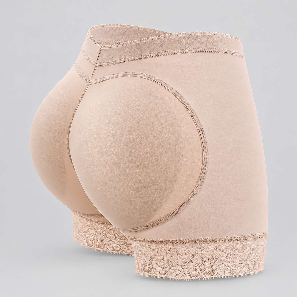 Beige hip enhancing shaper shorts shown from a rear three-quarter angle on a light gray background.
