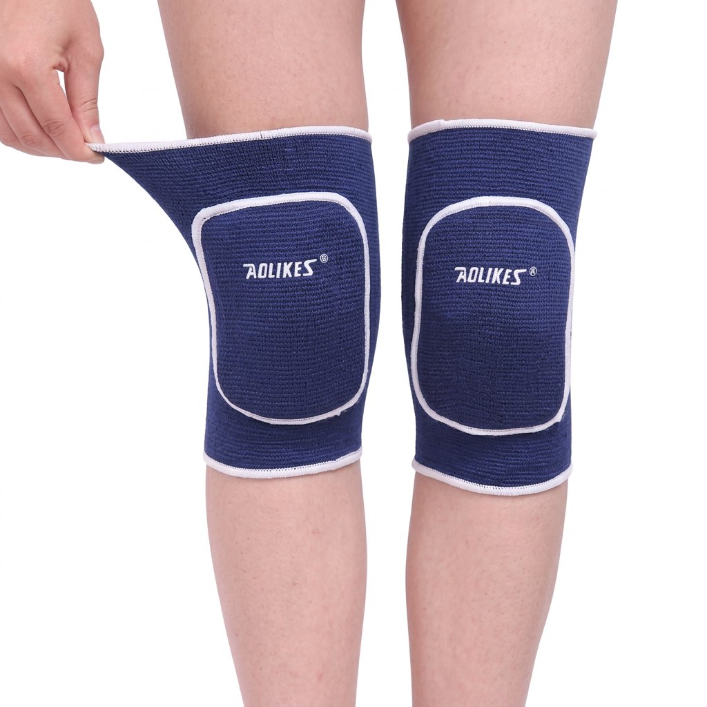 Blue kids knee pad sleeves with white trim and rounded front cushioning, shown on legs with a hand pulling the upper cuff.