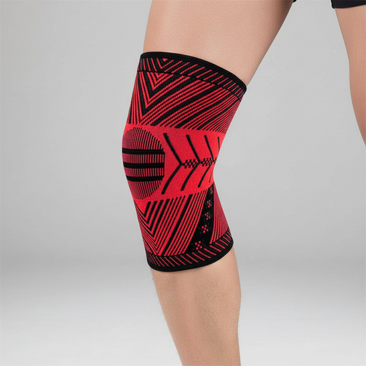 A red and black patterned knee wrap with strap worn on a person's knee, shown against a neutral light gray studio background.