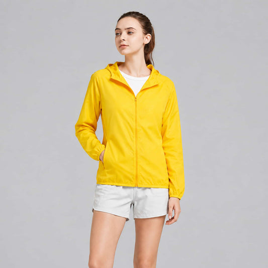 A woman modeling a lightweight packable rain jacket, photographed against a plain light gray studio background.