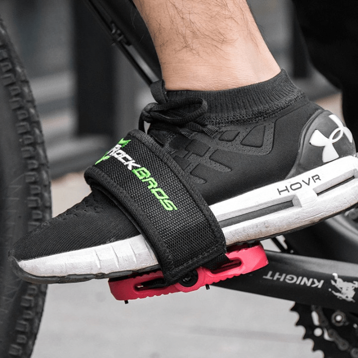 Side view of a sneaker secured tightly into a platform bicycle pedal using a non-slip bike toe strap.