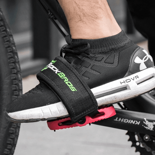 Side view of a sneaker secured tightly into a platform bicycle pedal using a non-slip bike toe strap.