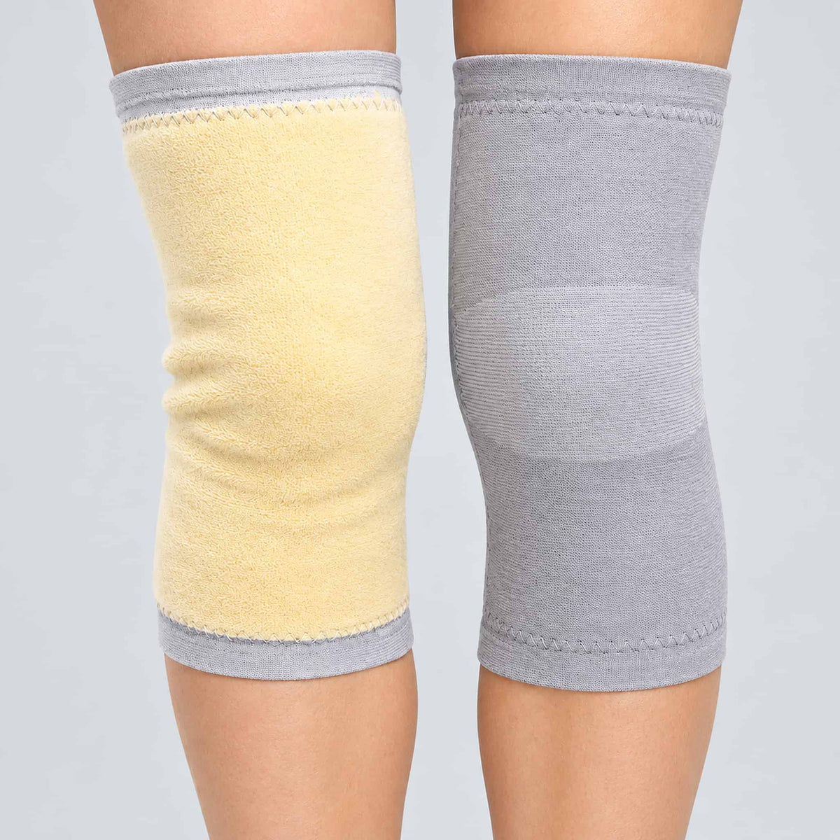 Two warm kneepad for cold weather shown on a model's legs against a light gray background. 